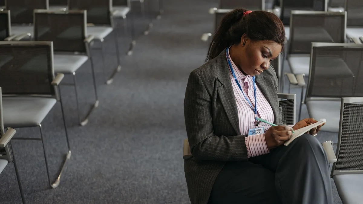 Professional woman writing notes in a quiet conference s