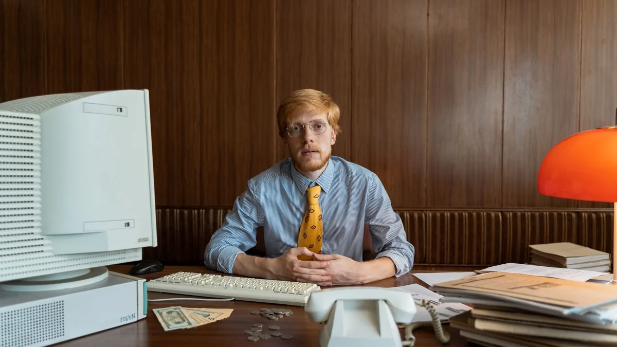 Retro office scene with businessman in tie at desk featu