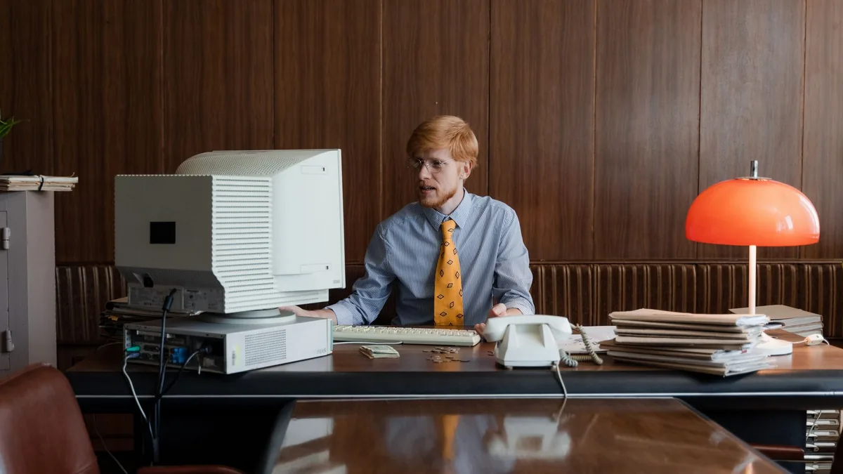 Retro office setup with a businessman working at a compu