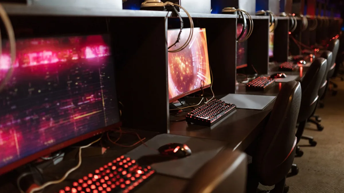 Row of gaming stations with illuminated keyboards and mo