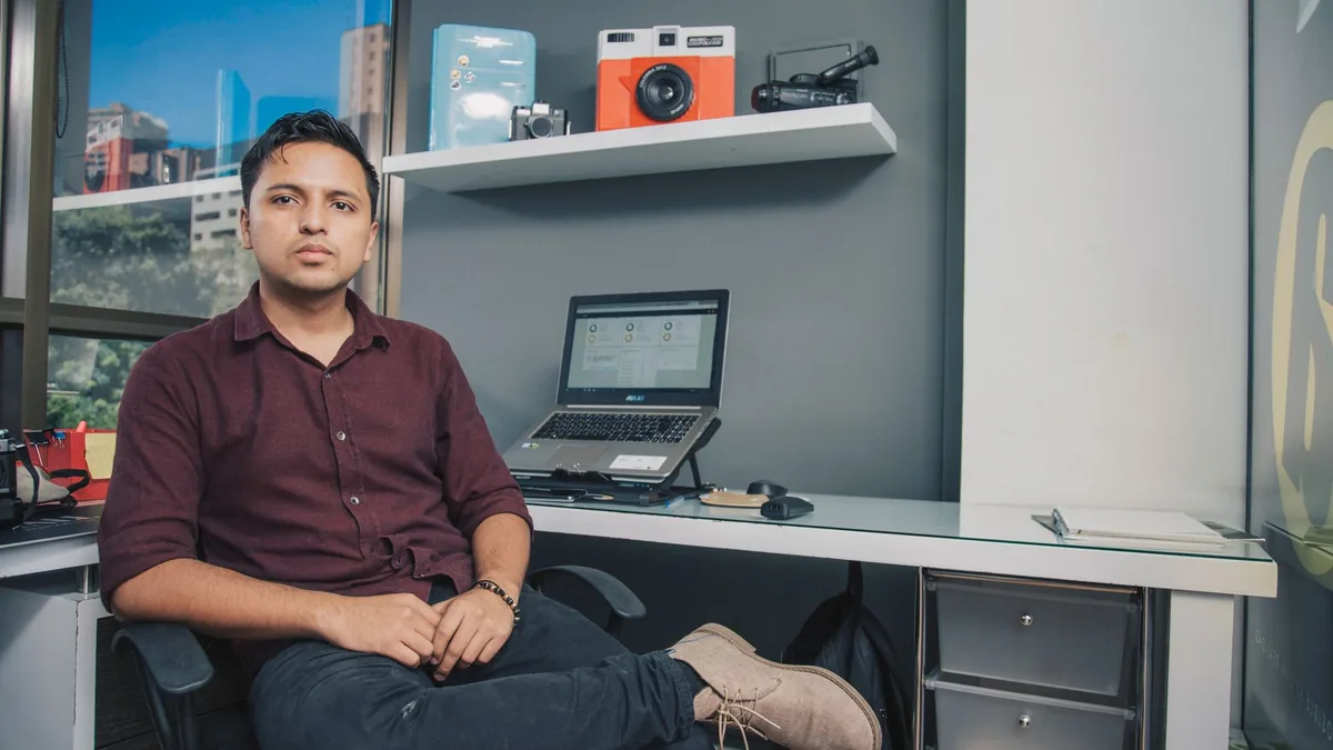 Serious male in casual clothes sitting with crossed legs