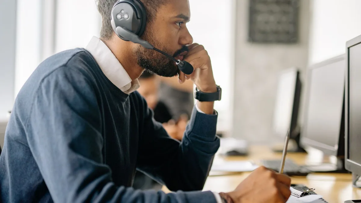 Side view of a bearded man in a headset concentrating at