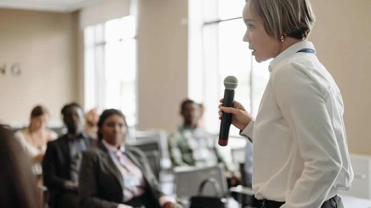 Side view of a businesswoman holding a microphone while