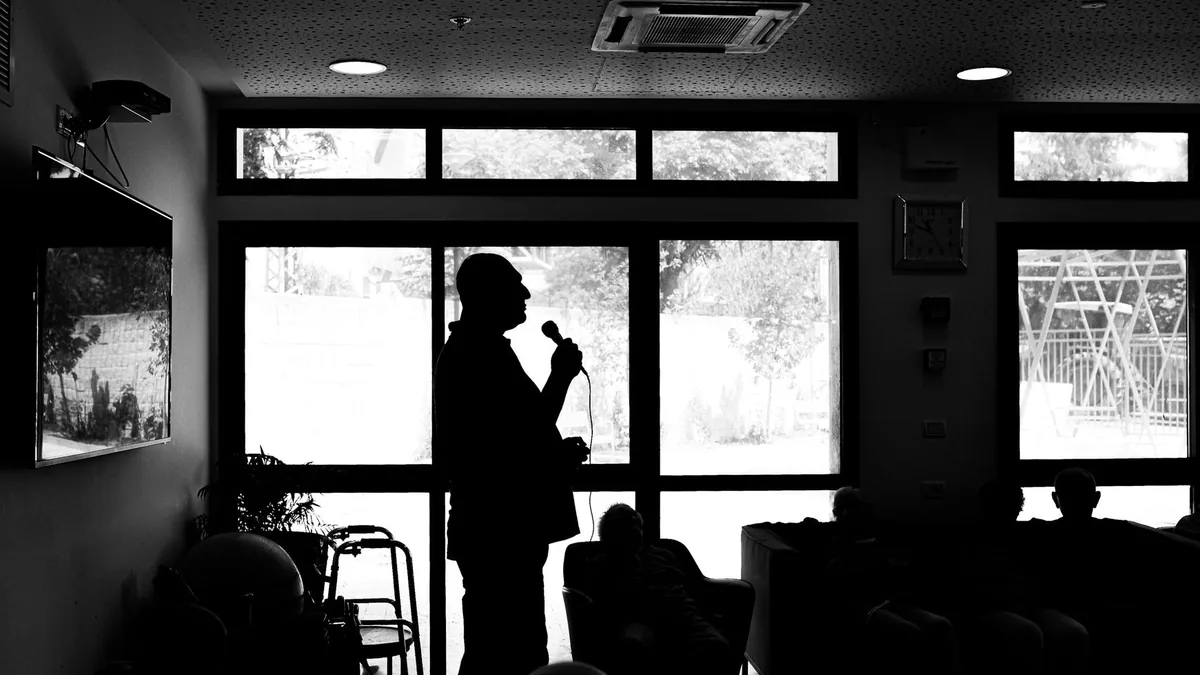 Silhouette of a person speaking indoors with an attentiv
