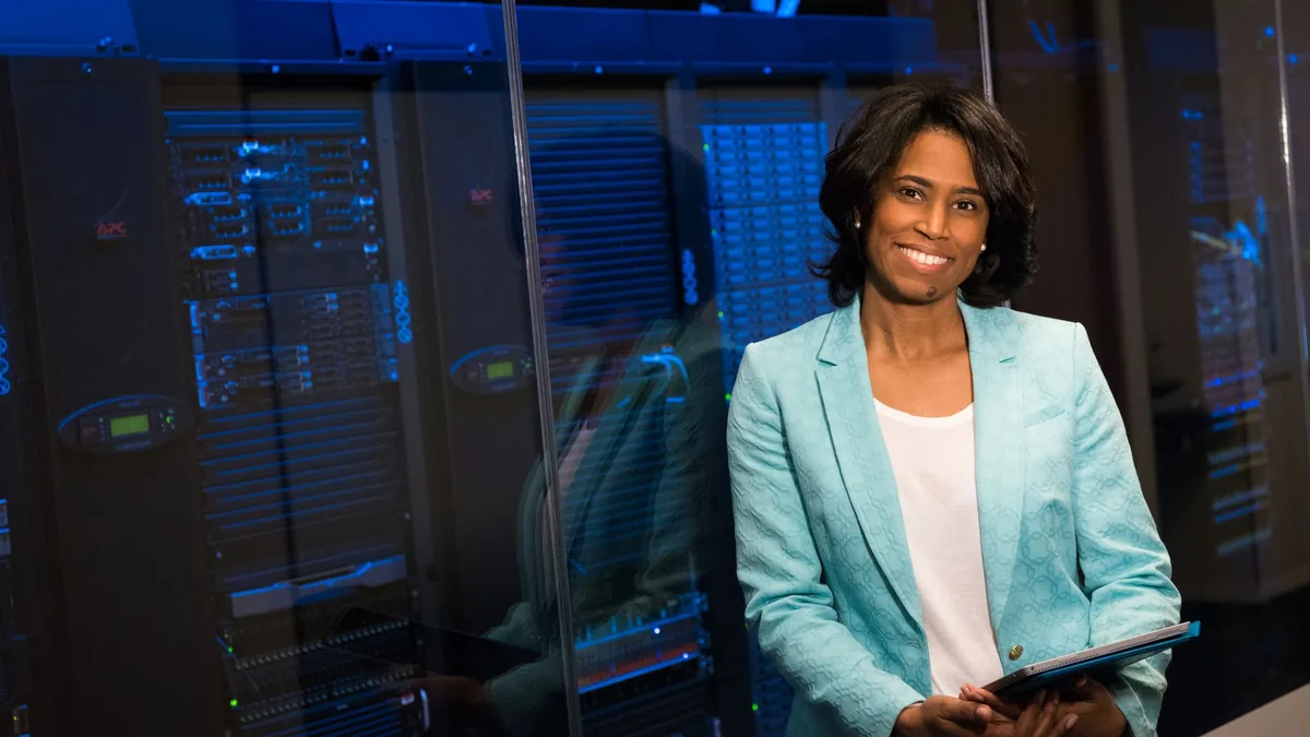 Smiling woman in data center showcasing technology exper