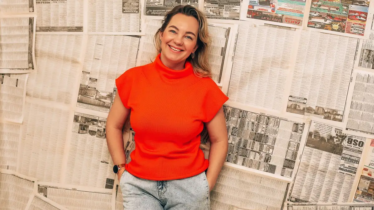 Smiling woman in vibrant red top posing confidently agai