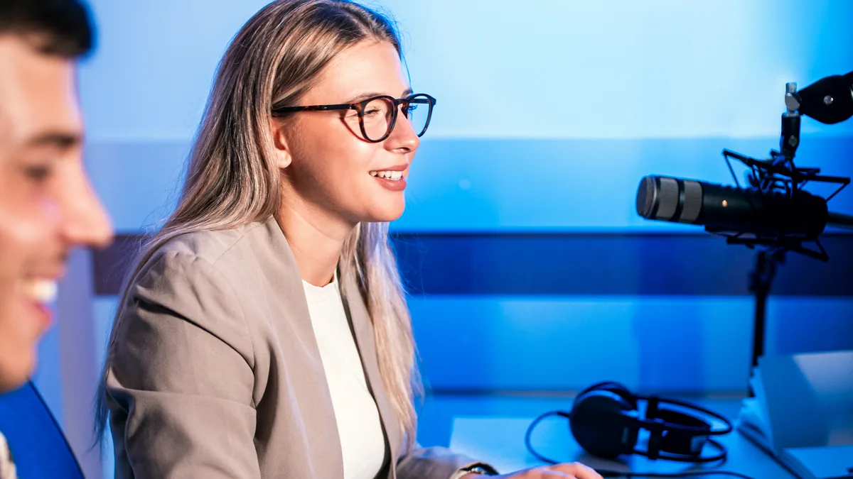 Podcast stüdyosunda birlikte çalışan iki kişi