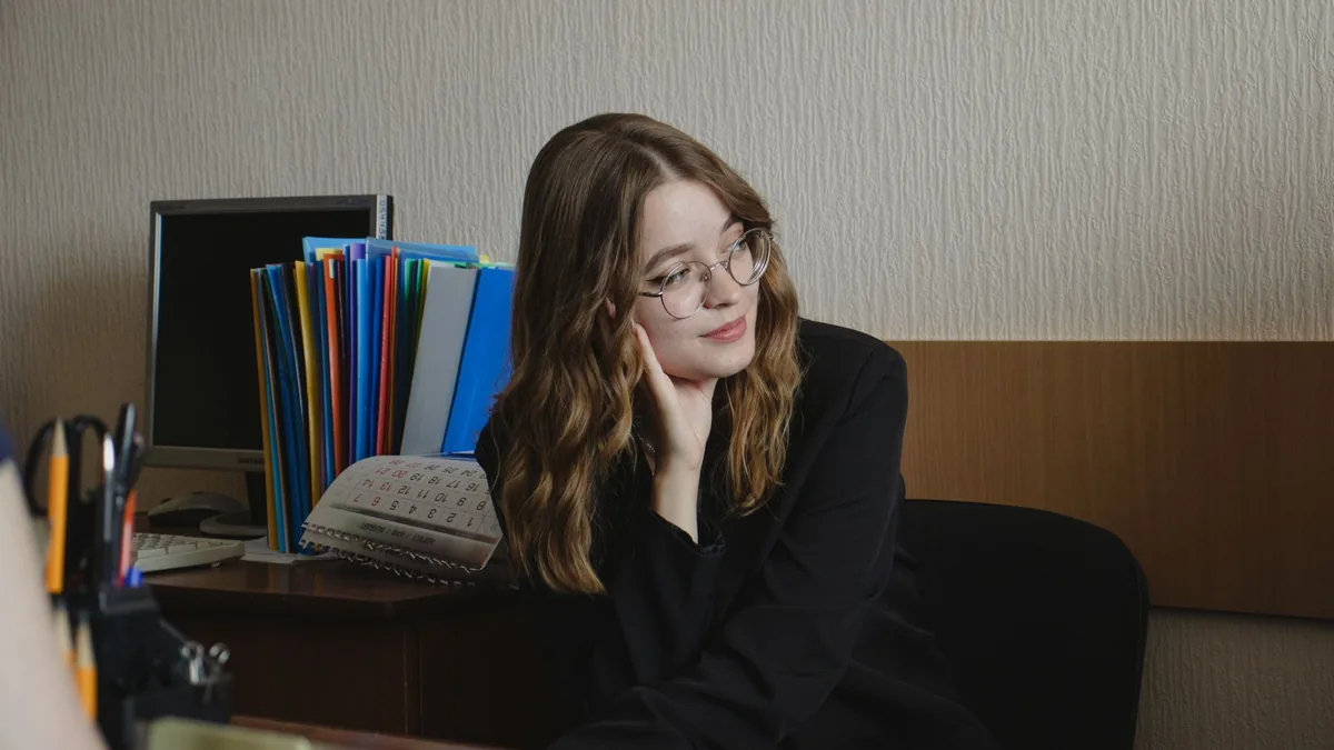 Smiling young woman sitting in an office setting wearing