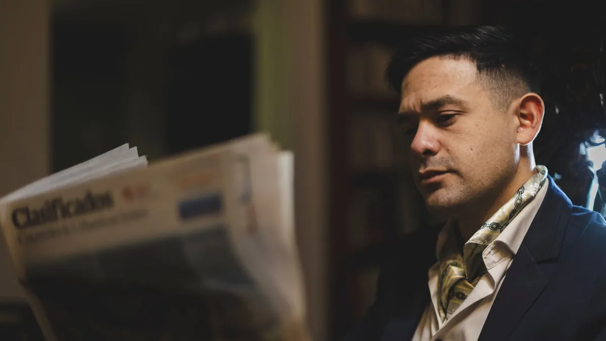 Sophisticated man reading a newspaper indoors captured i