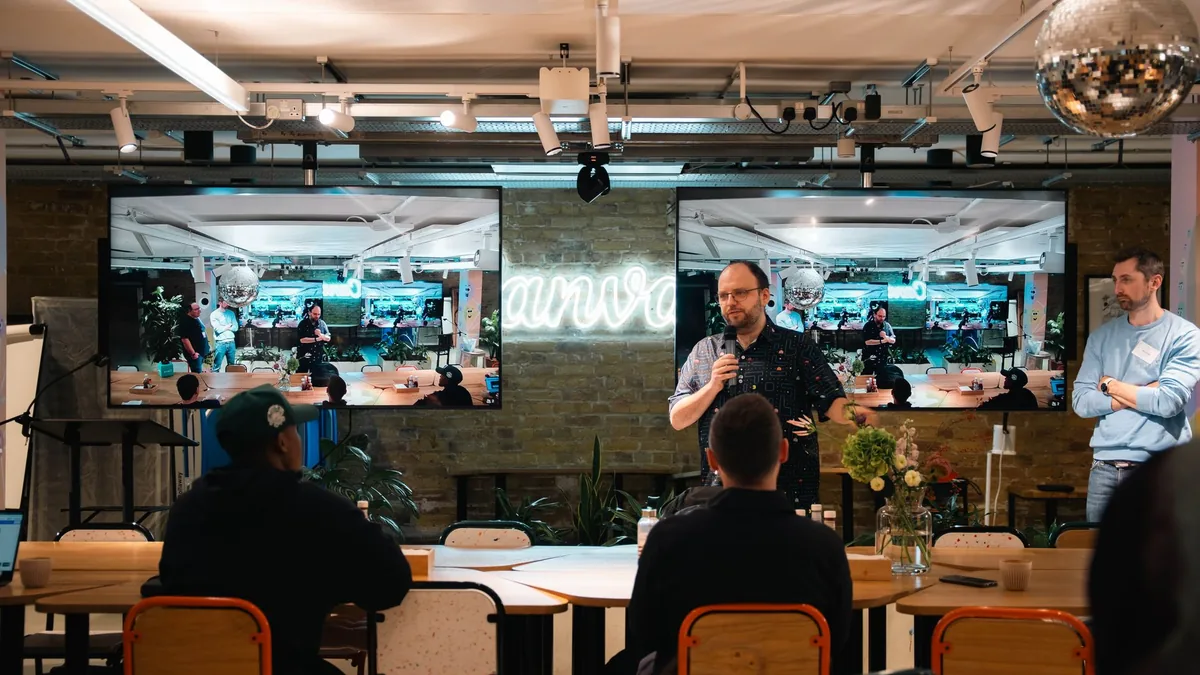 Speaker addresses audience in a modern indoor conference