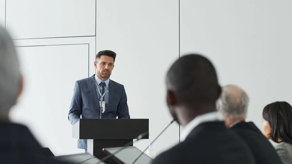 Speaker at a conference delivering a presentation to a d