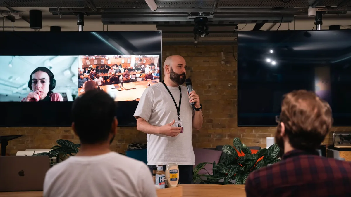 Speaker presenting in a modern office with audience and
