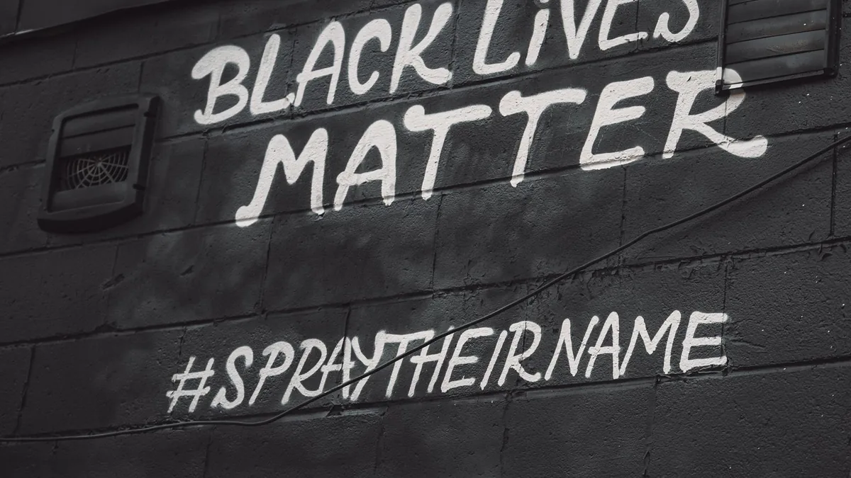 Street art displaying black lives matter slogan and hash