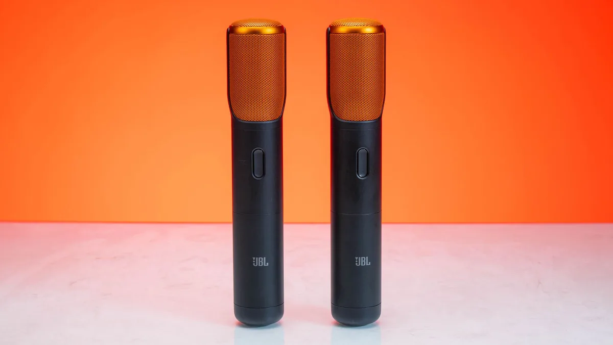 Stylish wireless microphones set against a bold orange b