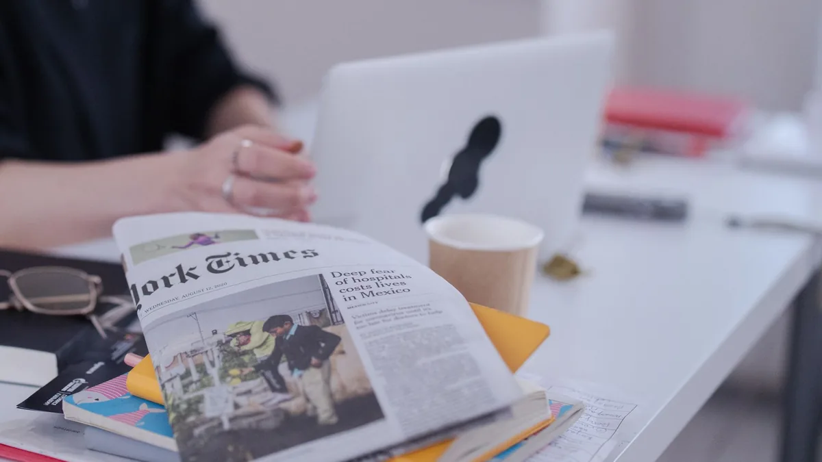 Stylized desk with newspaper books and coffee in a moder