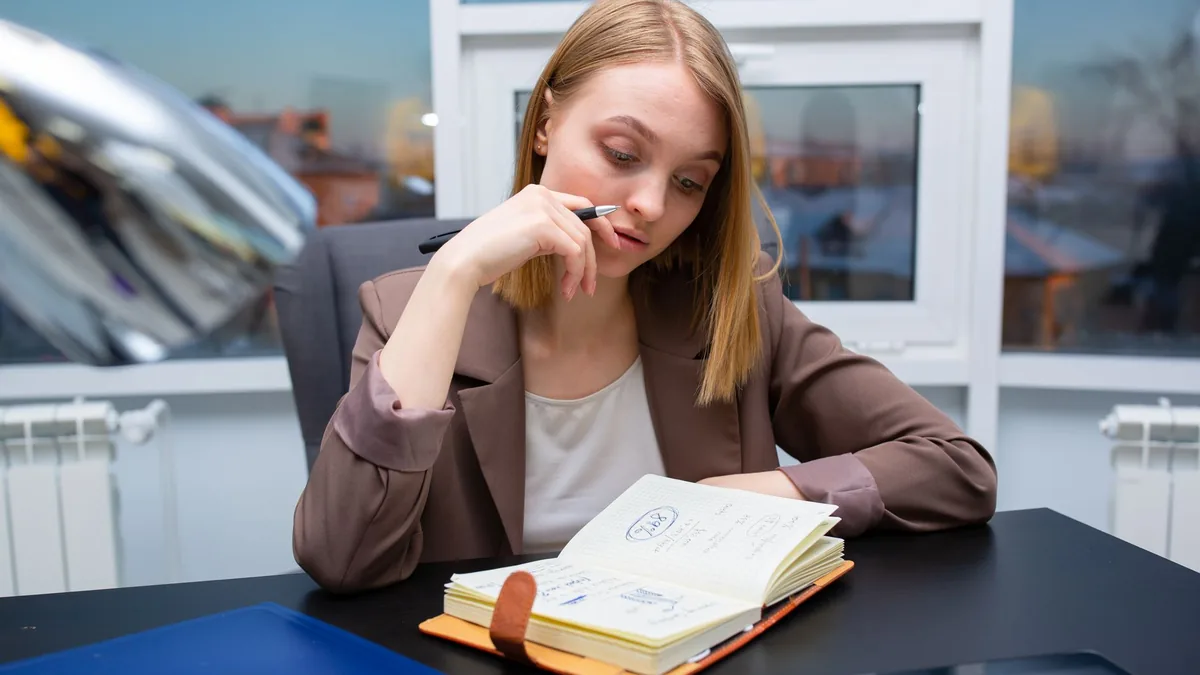 Thoughtful businesswoman planning her schedule at a mode