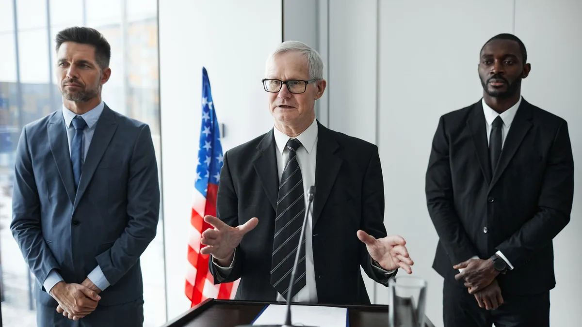 Three business professionals giving a speech with an ame