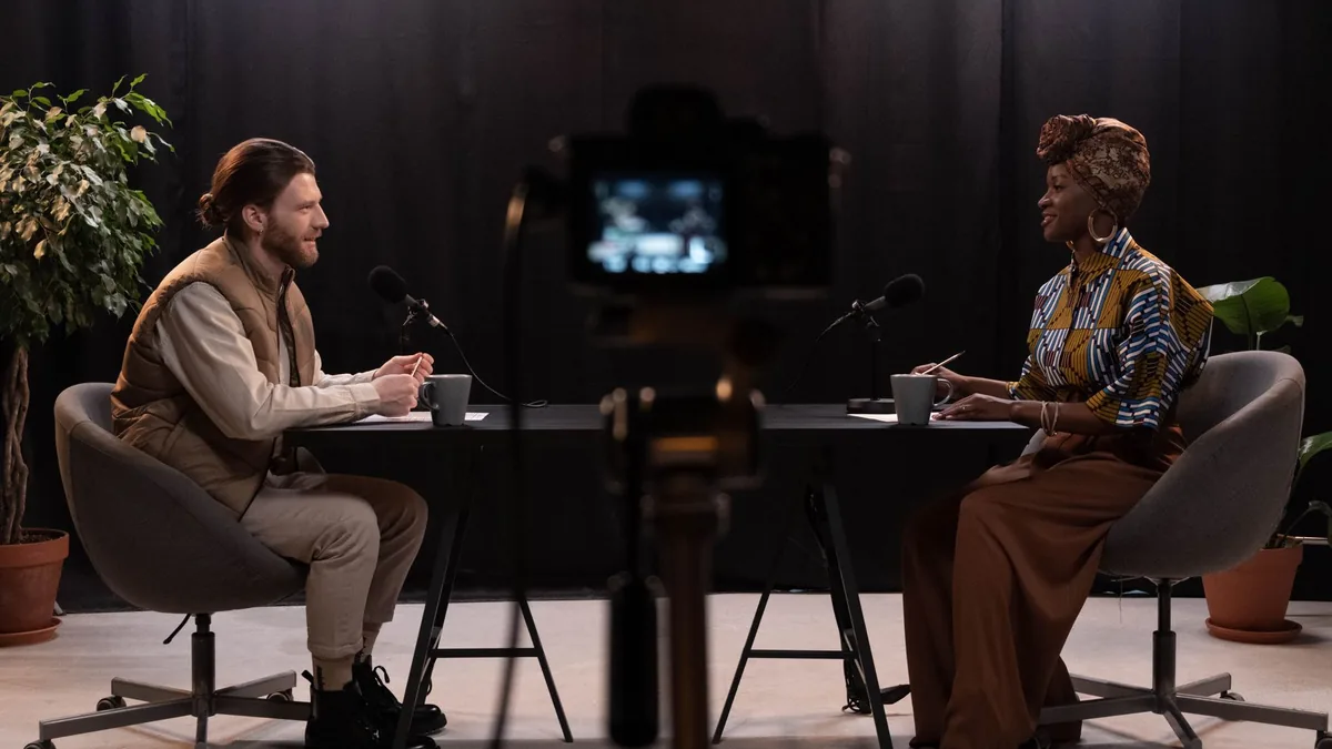 Two adults engaging in a podcast discussion in a studio