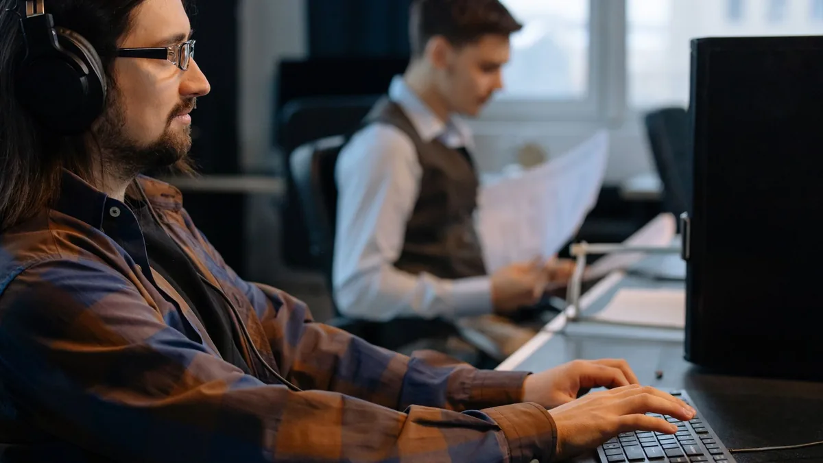 Two office workers focused on tasks at their desks in a