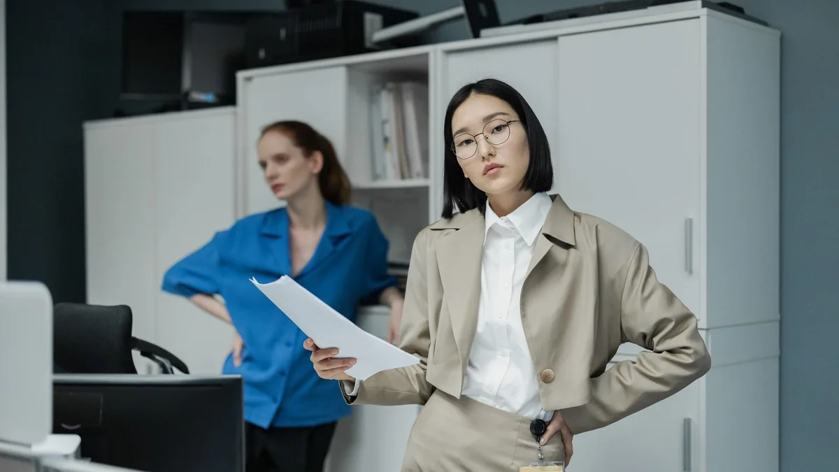 Two professional women working in a modern office settin