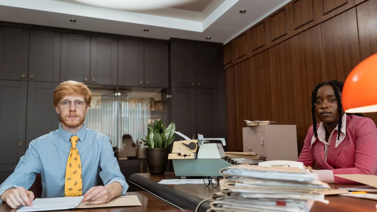Two professionals in a retro office setting sharing a wo