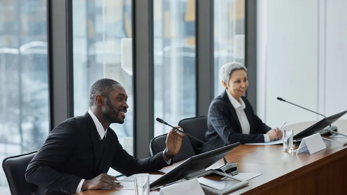 Two professionals speaking at a business conference in a