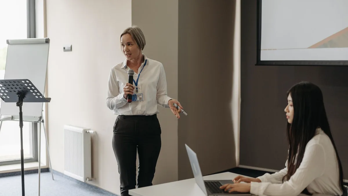 Two women in a business meeting with a presentation and
