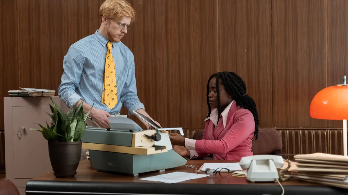 Vintage office setup with typewriter and colleagues in b