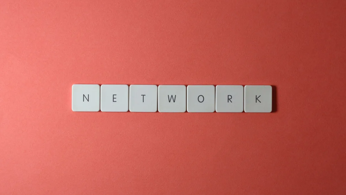 White keyboard tiles spelling network on a vibrant red s