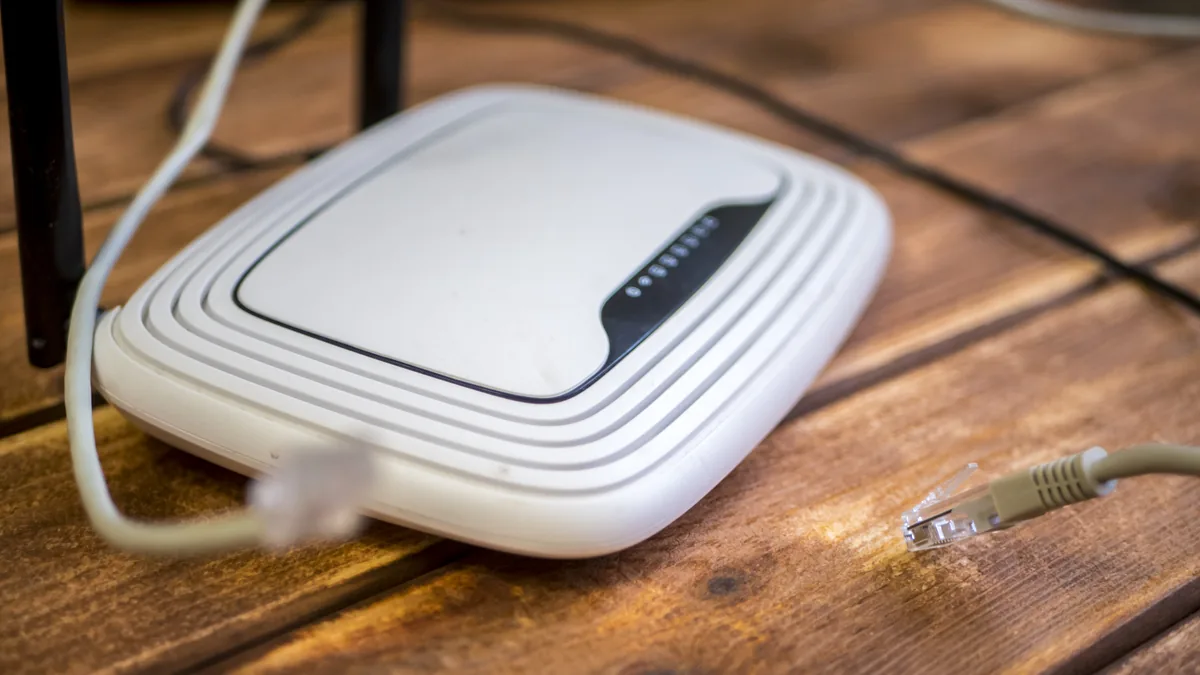 Ahşap yüzeyde kablolu beyaz kablosuz modem