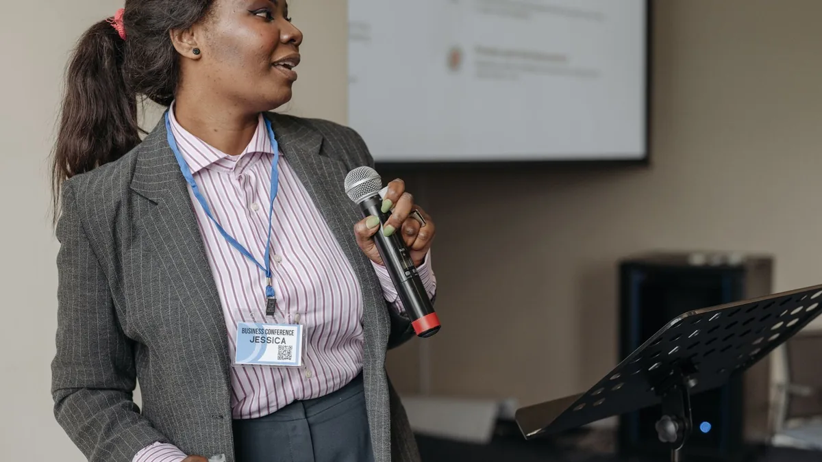 Woman in professional attire presenting at a business se