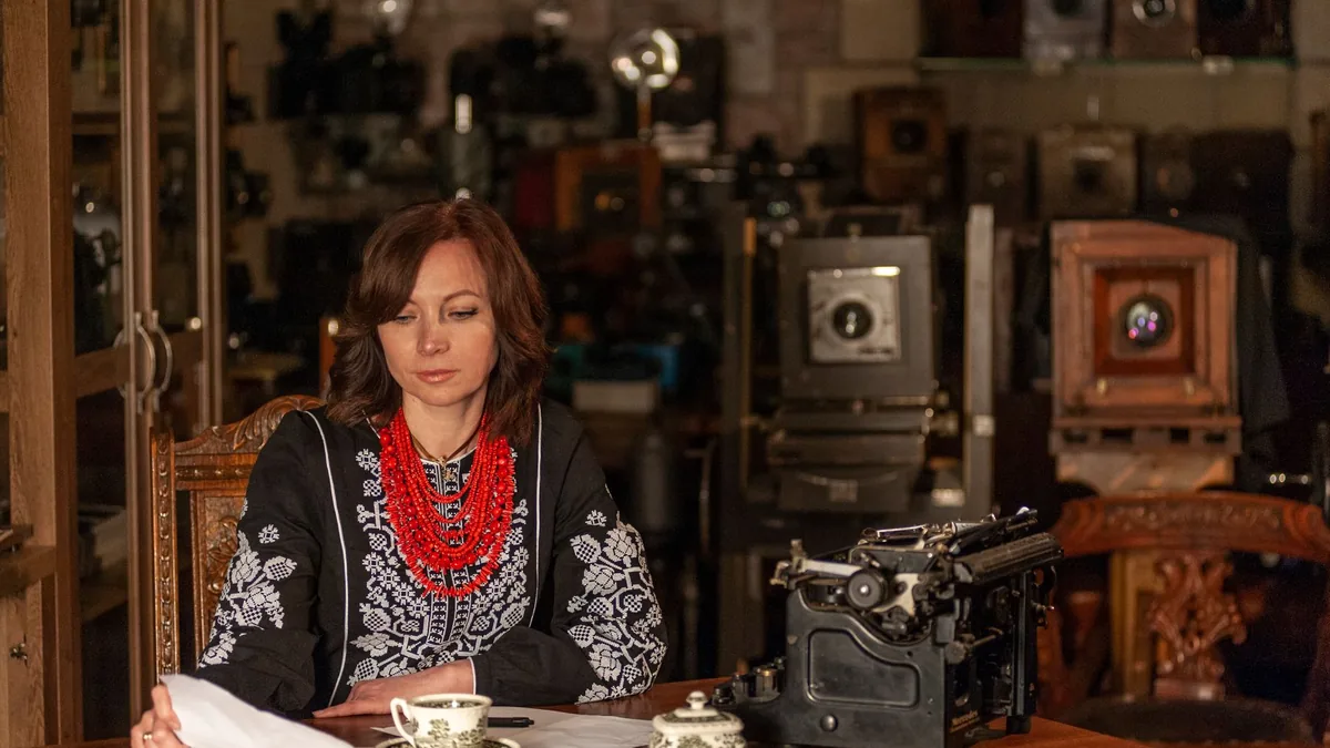 Woman in traditional ukrainian clothing sits at a vintag