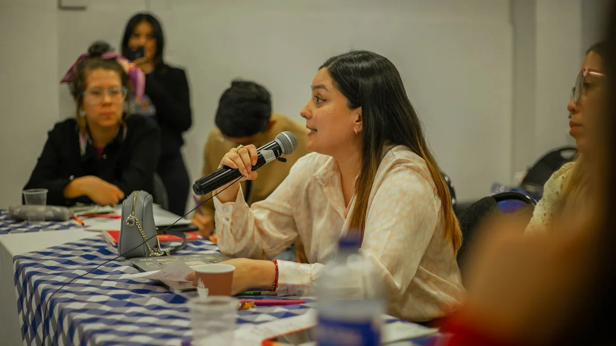 Woman participating in a group discussion holding a micr