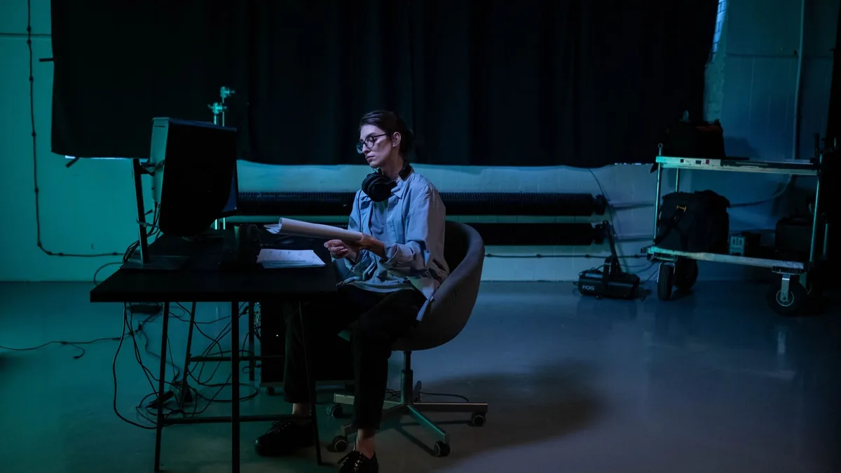 Woman working late in a moody studio environment concent