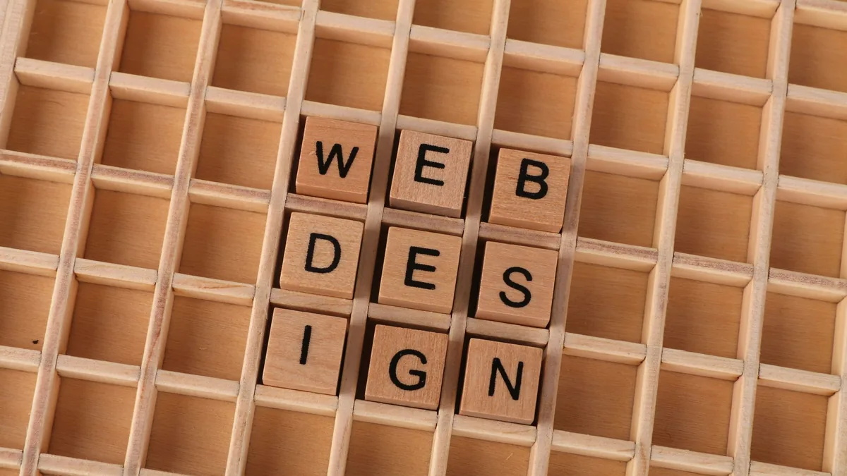 Wooden blocks spelling web design on a grid background s