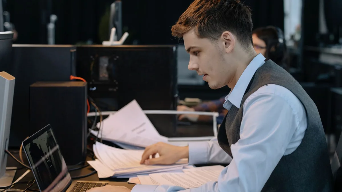 Young male professional focused on work with laptop and