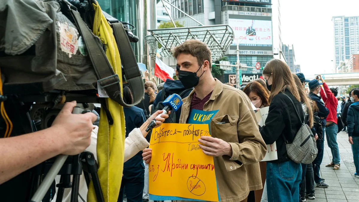 Young man holds protest sign during street demonstration