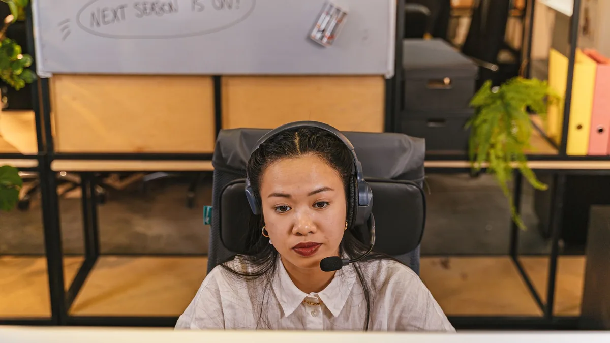Young woman focused on work using headset in modern offi