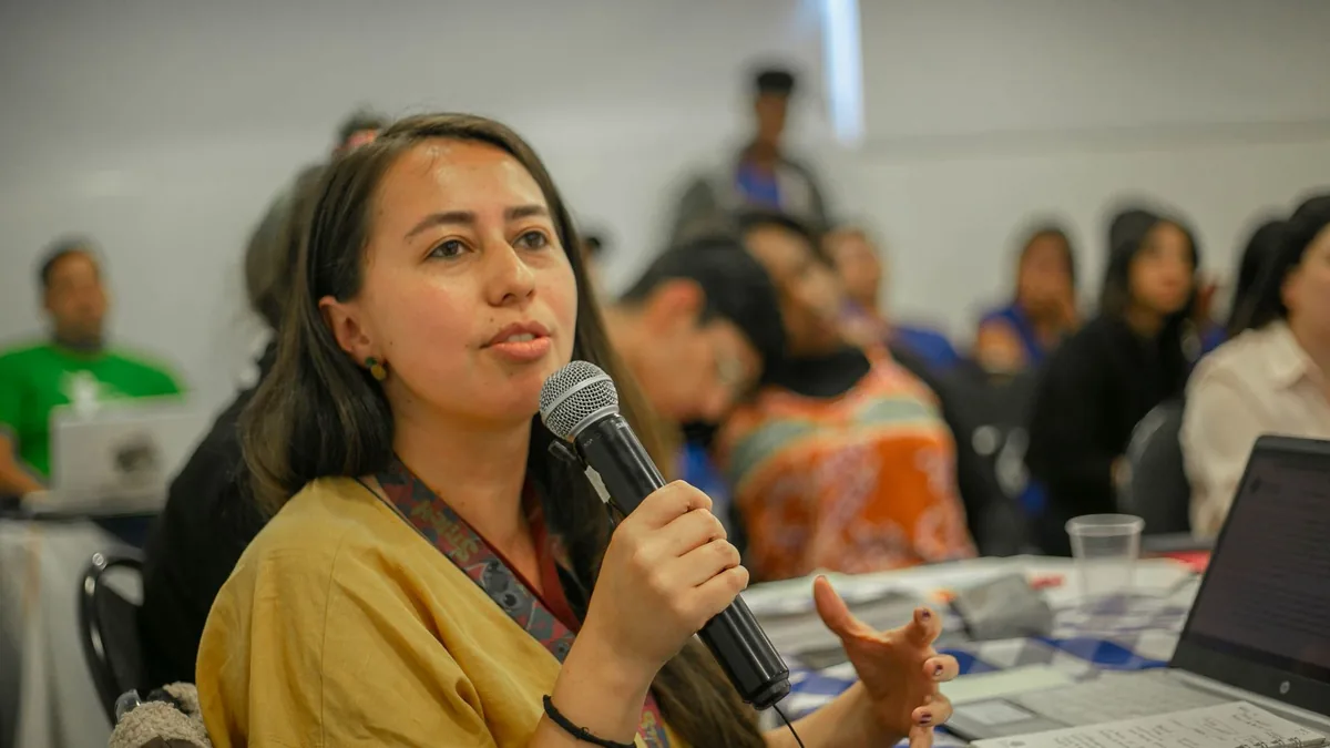 Young woman with microphone speaking during a classroom